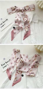 Pink silk skinny scarf with autumn pumpkin print tied on white shirt collar
