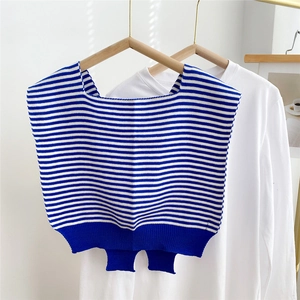 Close-up of blue striped knitted shawl vest over white long sleeve shirt for casual style