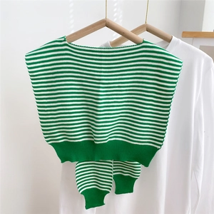 Detail view of green and white striped knitted vest with matching arm sleeves on a hanger