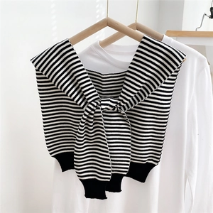 Detail of a black and white striped knitted shawl with front tie on a white shirt