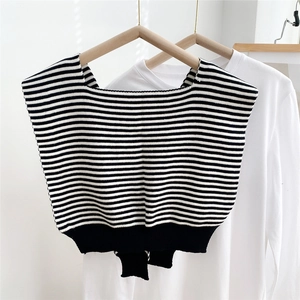 Detail of knitted black and white striped shawl wrap showing ribbed hem and fabric texture