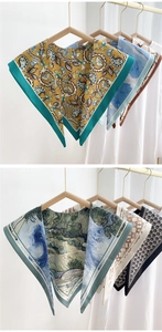 Detail view of premium silk scarves with paisley and artistic prints on hangers