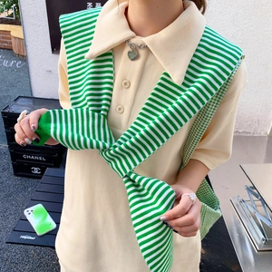 Women stripe knit shawl over a beige polo shirt for a stylish casual outdoor autumn look
