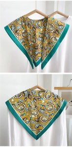Detailed view of yellow and teal paisley silk scarf with elegant vintage patterns