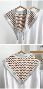 Detail of triangular scarf with geometric pattern and loves handwritten embroidery