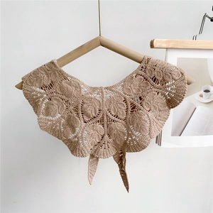 Close-up of beige crochet hollow leaf pattern texture on elegant knitted shawl