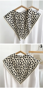 Detail of vintage beige floral collar with black daisy print and striped edges