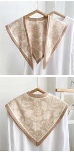 Detail of champagne floral triangle shawl scarf draped on a white T-shirt