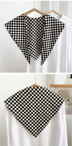 Detail of black and white checkerboard decorative shawl with pointed collar design