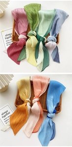 Detail of multi-color accordion pleated skinny silk scarf showing high-density fabric texture