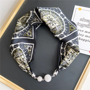 Close-up of silk scarf necklace with vintage compass print and rhinestone magnetic buckle