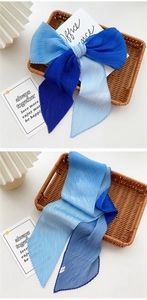 Macro detail of pleated gradient blue silk scarf showing fine organza texture and bow