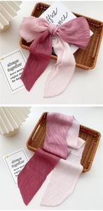 Detail of pink and burgundy pleated silk scarf showing vertical accordion texture and soft fabric