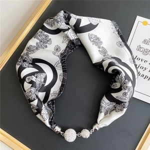 Detail of silk scarf necklace with crystal pavé balls and black and white leaf prints