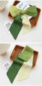 Detail of pleated silk scarf with green and yellow gradient texture and soft fabric