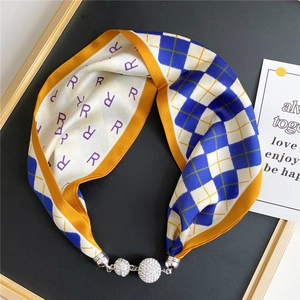 Close-up of silk scarf necklace with magnetic buckle, grid patterns and crystal pendants