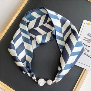 Macro detail of silk scarf necklace with geometric blue stripes and rhinestone spheres
