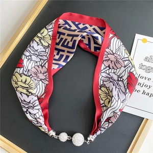 Detail of silk-feel floral scarf necklace with rhinestone magnetic balls and geometric patterns