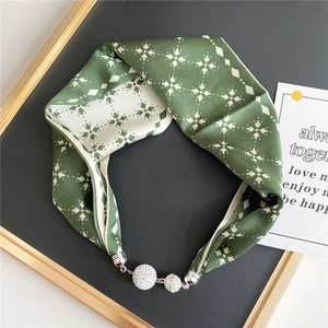Detail of silk scarf necklace with silver magnetic clasp and sparkling floral patterns