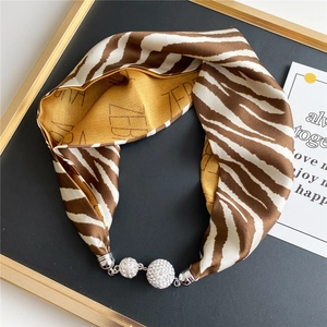 Macro shot of zebra print scarf necklace with sparkling rhinestone studded silver spheres
