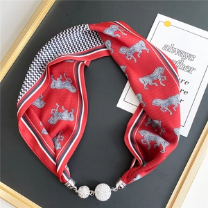 Detail of red silk scarf necklace with horse print and rhinestone magnetic buckles