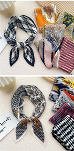 Close-up of pleated silk scarves featuring houndstooth and vintage patterns on a wooden tray