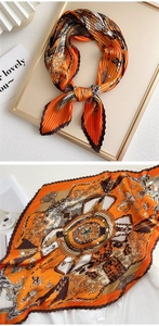 Detail of pleated silk scarf with baroque horse print and elegant orange satin finish