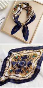 Detailed view of pleated silk scarf featuring classic navy and gold baroque chain print