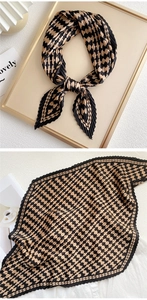 Detail of pleated square scarf featuring classic houndstooth pattern and wavy edges