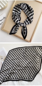 Detail of pleated silk scarf featuring black and white checkerboard pattern and wavy texture