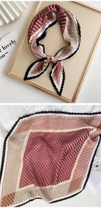 Detail of red houndstooth pleated scarf with wavy black borders and gold stripe accents