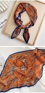 Detail of pleated silk scarf with vintage orange and blue patterns in high gloss finish
