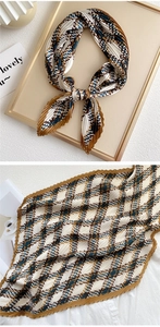 Detail of pleated silk scarf with houndstooth pattern in green and brown tones