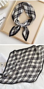 Detailed close-up of pleated silk scarf featuring classic black and white houndstooth pattern
