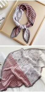 Detail of pleated silk scarf featuring striped patterns and floral patchwork texture