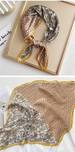 Macro view of pleated scarf with brown houndstooth and grey paisley pattern details