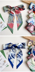 Detail of elegant silk scarfs showing floral bird and ocean wave patterns in bow styles