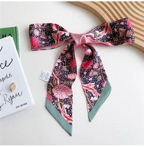 Detailed view of floral silk necktie with pink patterns and contrasting green border edges