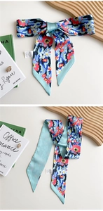 Close-up of light blue floral long silk scarf with retro patterns and care label