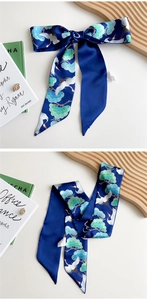 Detail of navy silk scarf with traditional crane print tied in an elegant bow knot