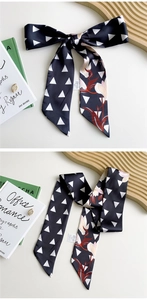 Detail of black geometric floral silk scarf with white triangles and magnolia patterns