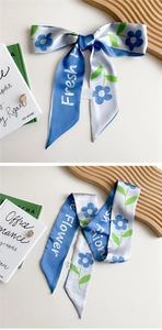 Detail view of blue and white silk flower twilly scarf with elegant satin finish