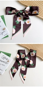 Detail of long coffee silk scarf with camellia floral patterns and pink border design