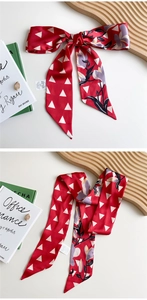 Detail of red floral satin scarf with geometric patterns and easy-to-remove care label