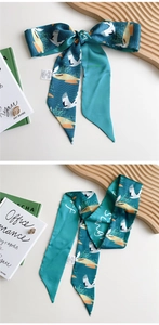 Detail of teal satin twilly scarf with elegant crane and wave patterns for women