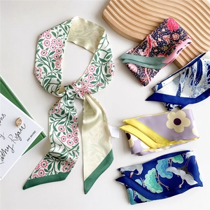 Collection of elegant floral and wave print silk twilly scarves on a minimal white background