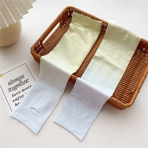 Detail of yellow gradient sun protection sleeves with thumb holes in a wicker basket