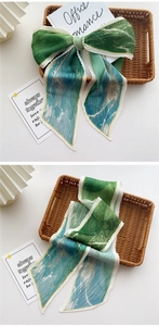 Détail d'un foulard plissé avec dégradé vert bleu et motif étoilé doré brillant