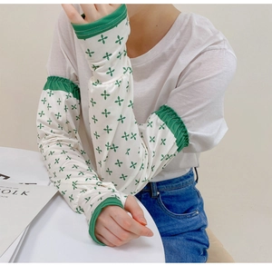 Close-up of lightweight floral sun protection sleeves with green elastic cuffs
