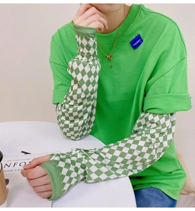 Detail of trendy two-piece layered long sleeve T-shirt with green checkerboard pattern sleeves